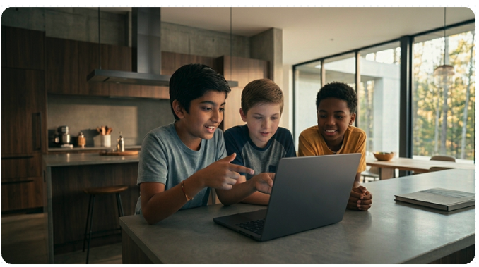 Three children gathered around a laptop and sharing an idea
